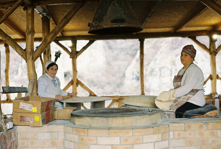 Bakers at work beside a clay tonir oven