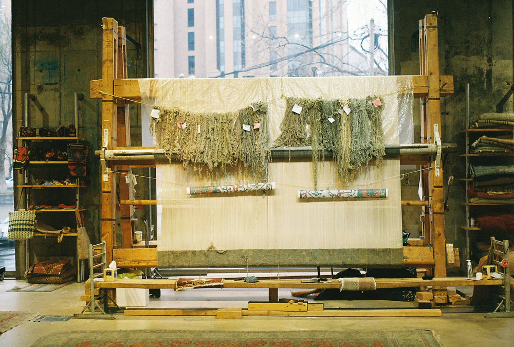A hand-knotted carpet in progress on a wooden loom