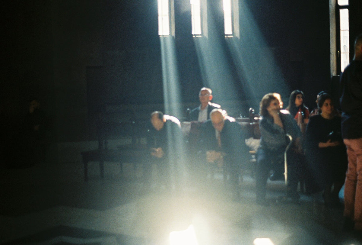 Shafts of light fall through the nave of an Armenian church during a service