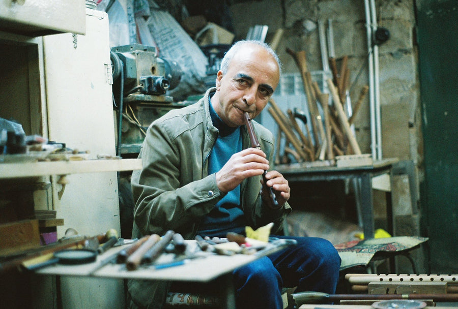 A duduk maker plays an instrument in his workshop
