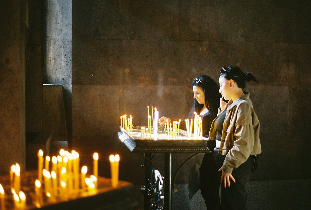 Worshippers light thin beeswax candles inside an Armenian church