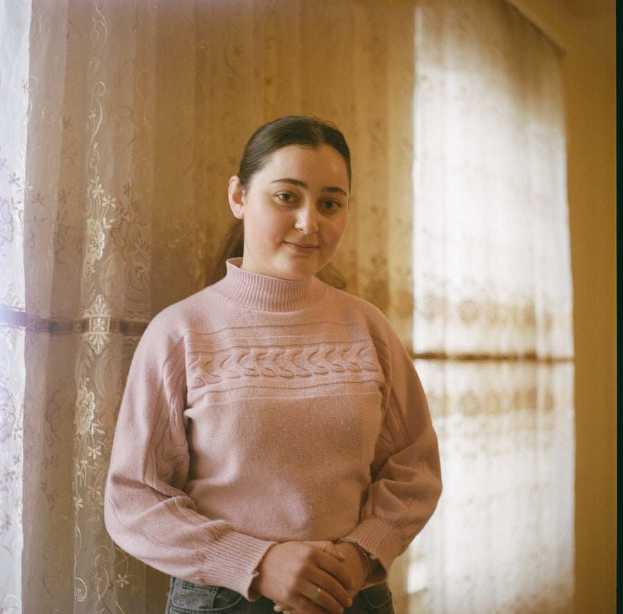 Portrait of a young Armenian woman by a lace-curtained window