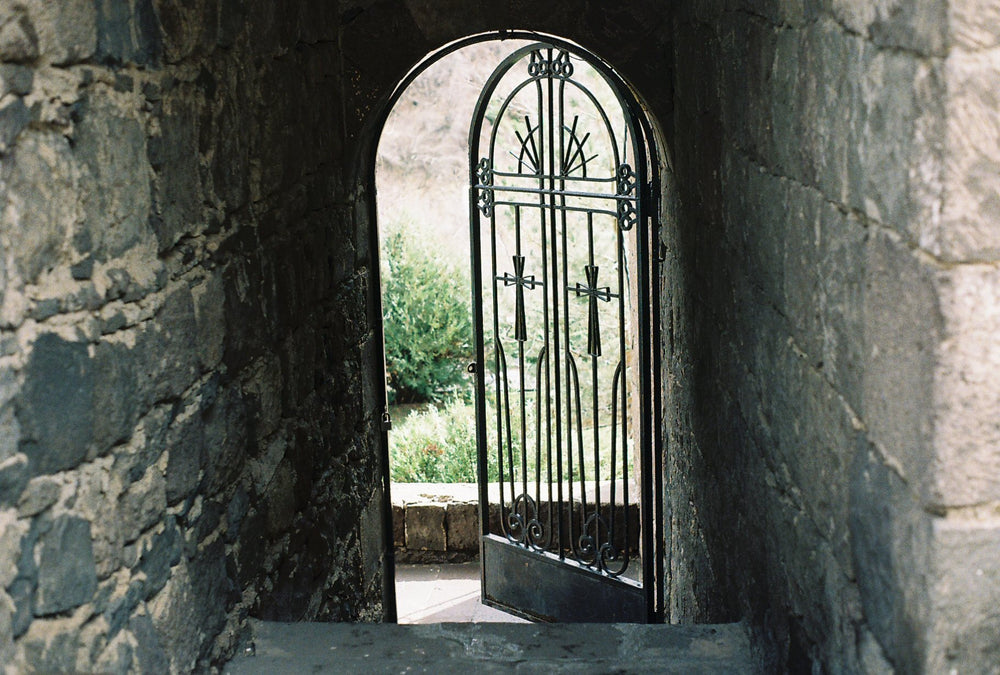 An iron gate at the end of a stone passage